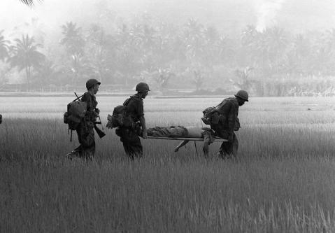 Tentera AS membawa seorang rakannya yang cedera parah merentasi sawah padi.